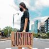 girl crossing street with justice sign