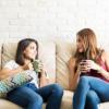 two women talking on a couch