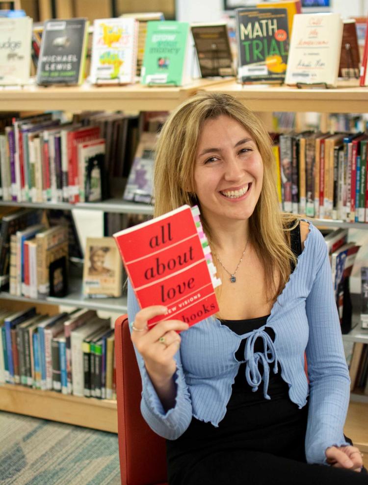 Photograph of Cassidy Ktsanes holding the book "All About Love"