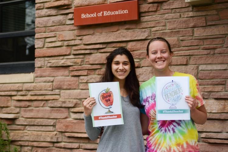 Anisah and Hannah holding #ThankATeacher signs