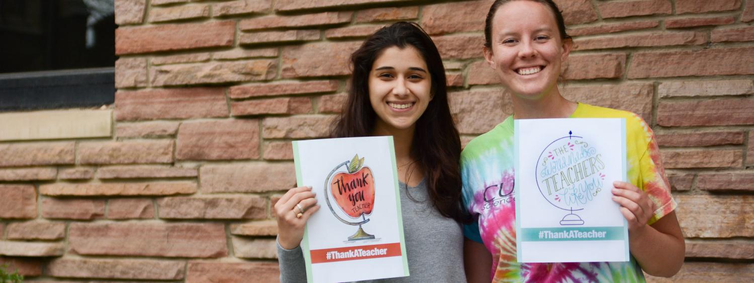 Anisah and Hannah holding #ThankATeacher signs