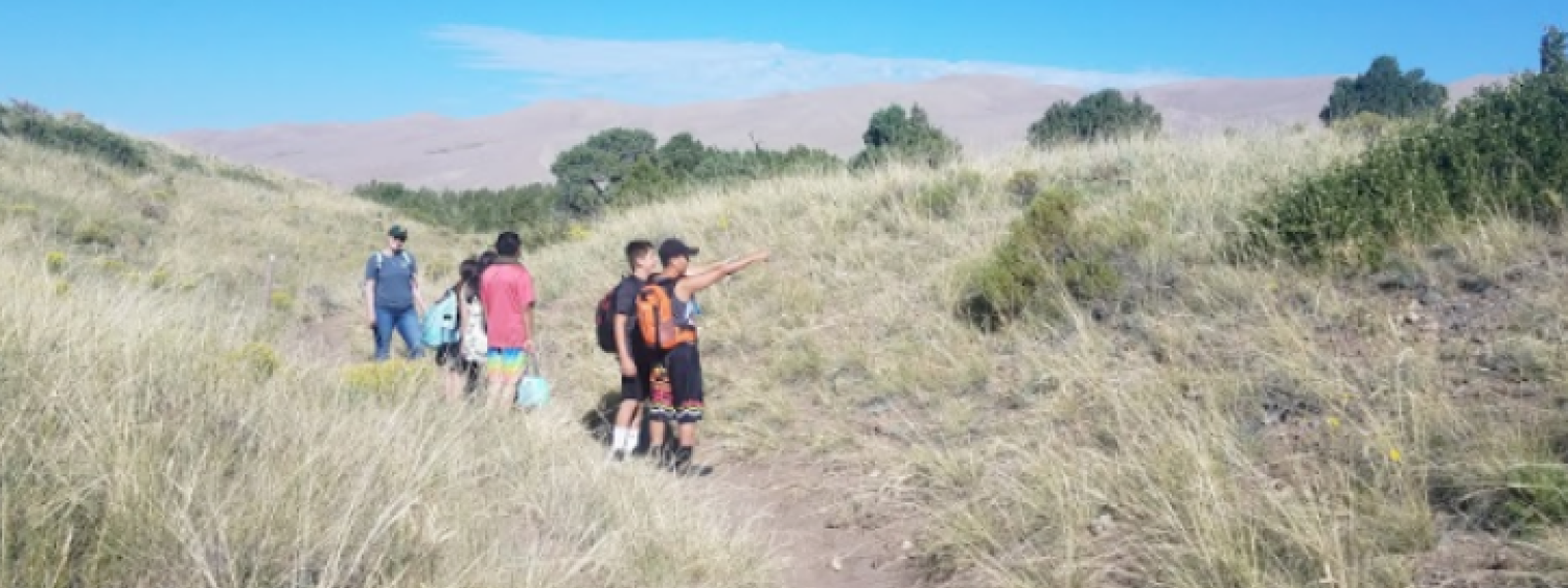 A snapshot from a field trip to the Great Sand Dunes shows a class of seventh graders learning about science under a sky wider than any classroom ceiling.