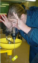 A woman demonstrating how to do an eye wash
