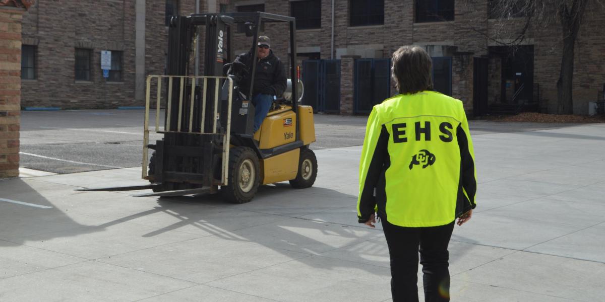 An EH&S worker helping someone with a forklift