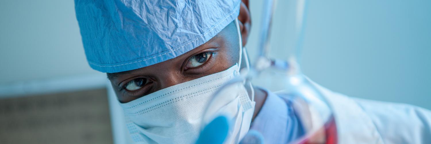 A person in a lab holding a beaker