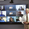Professor Moorer in front of screen with distance students