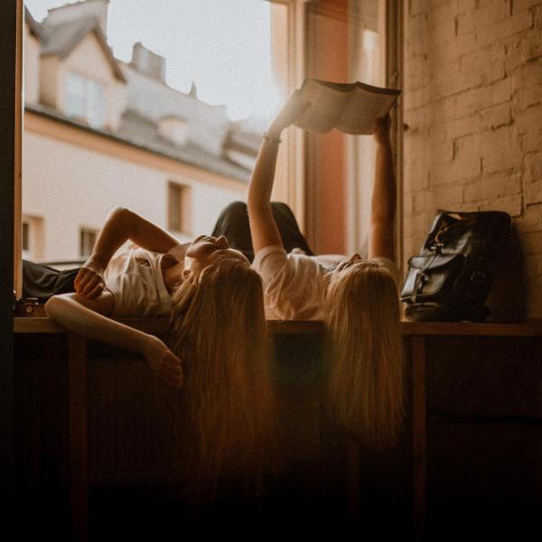 girls reading while lying on their backs