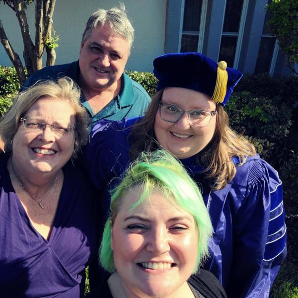 Rachel (in blue tam and gown) celebrates her PhD graduation with her family