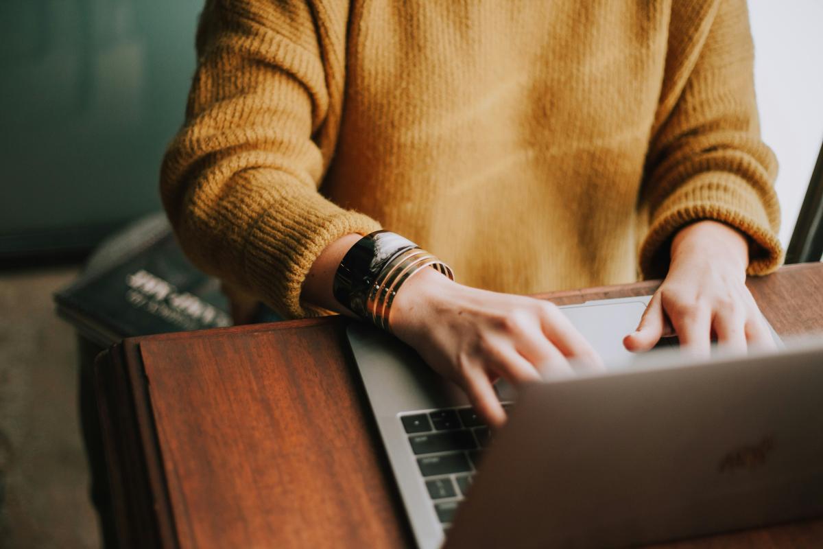 A person works on a laptop at their desk