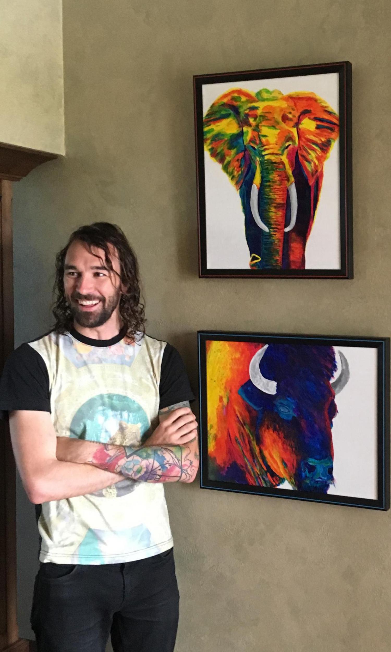 Carson Bruns poses with paintings he created