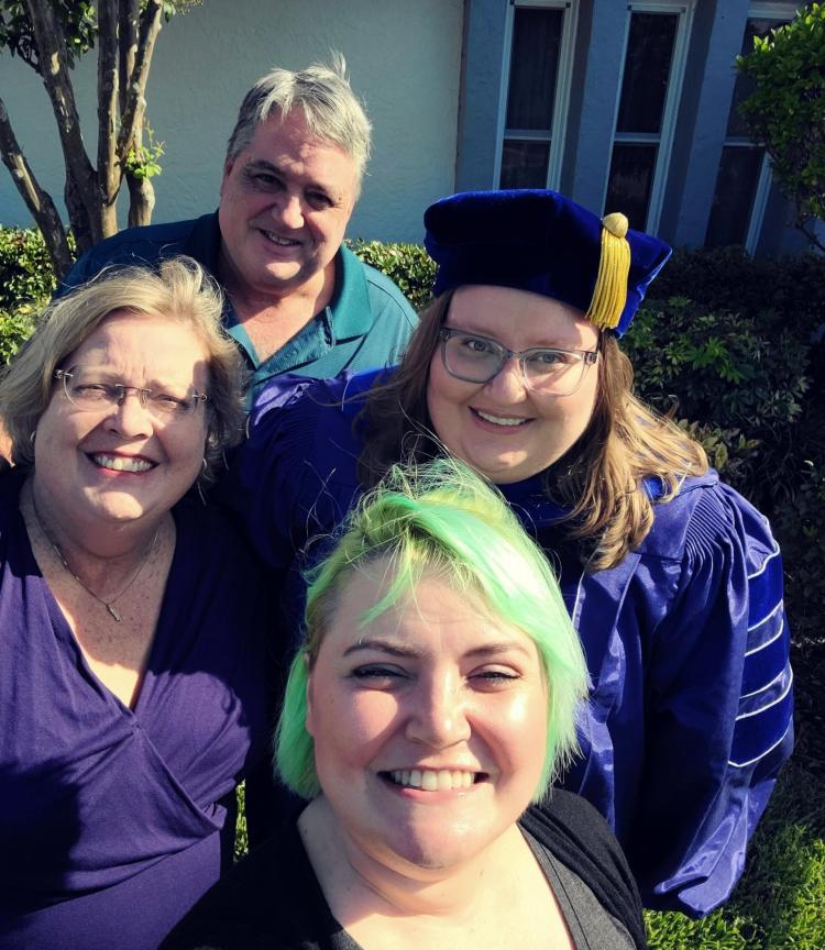 Rachel (in blue tam and gown) celebrates her PhD graduation with her family