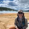 Victoria sits on the boardwalk next to a hot spring in Yellowstone