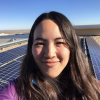 Kyri Baker poses in front of solar panels 