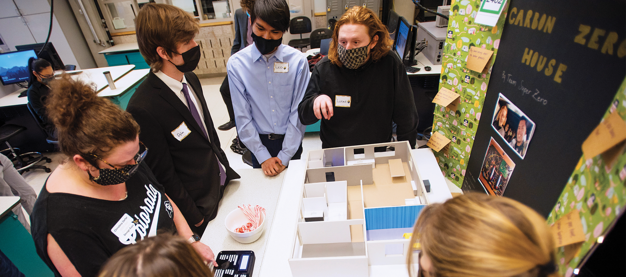 A student team sponsored by King shows off its carbon-zero home design at a project expo