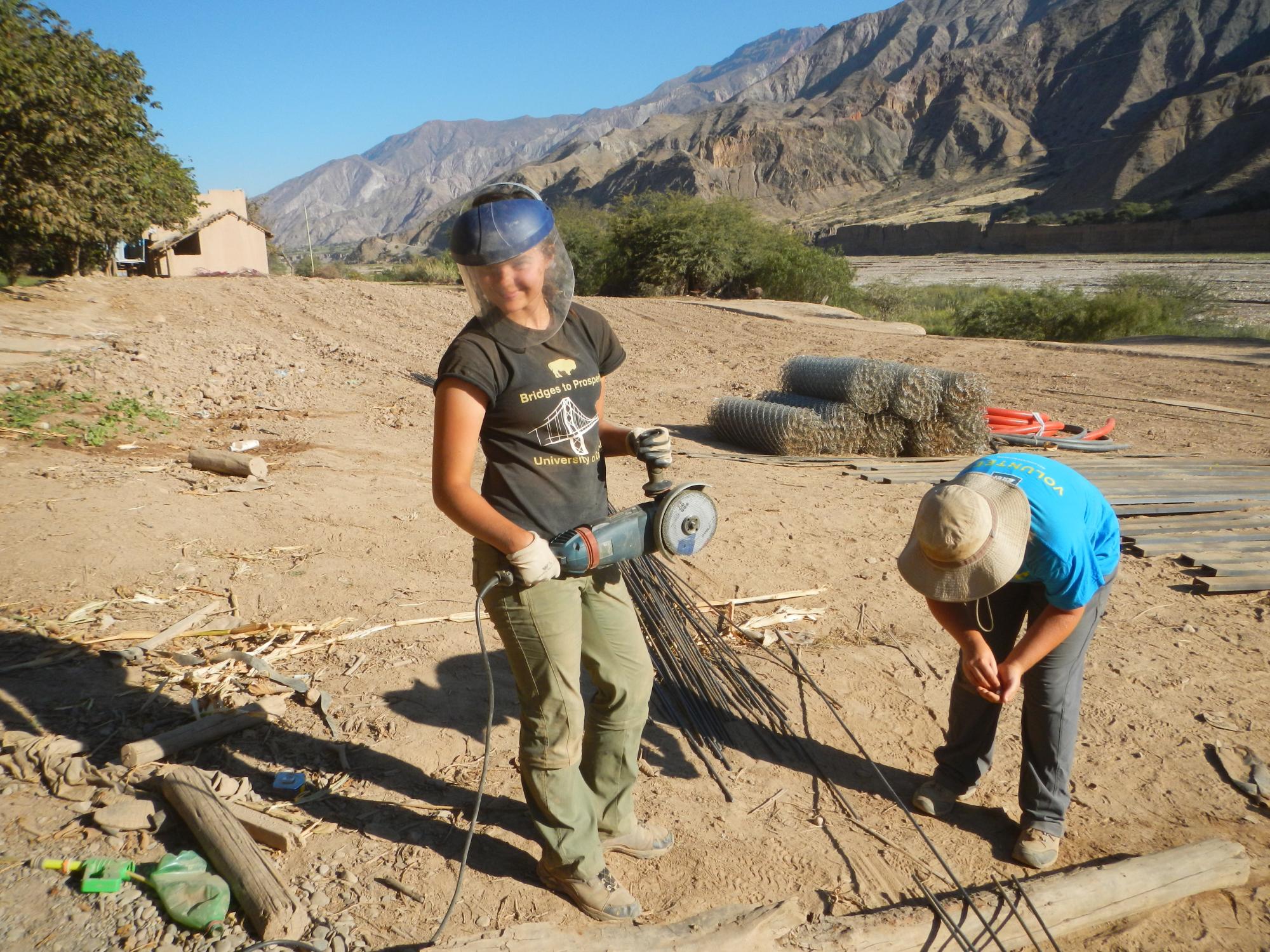 Zoey Craun uses a metal cutting saw on a Bridges to Prosperity job site in Bolivia. 