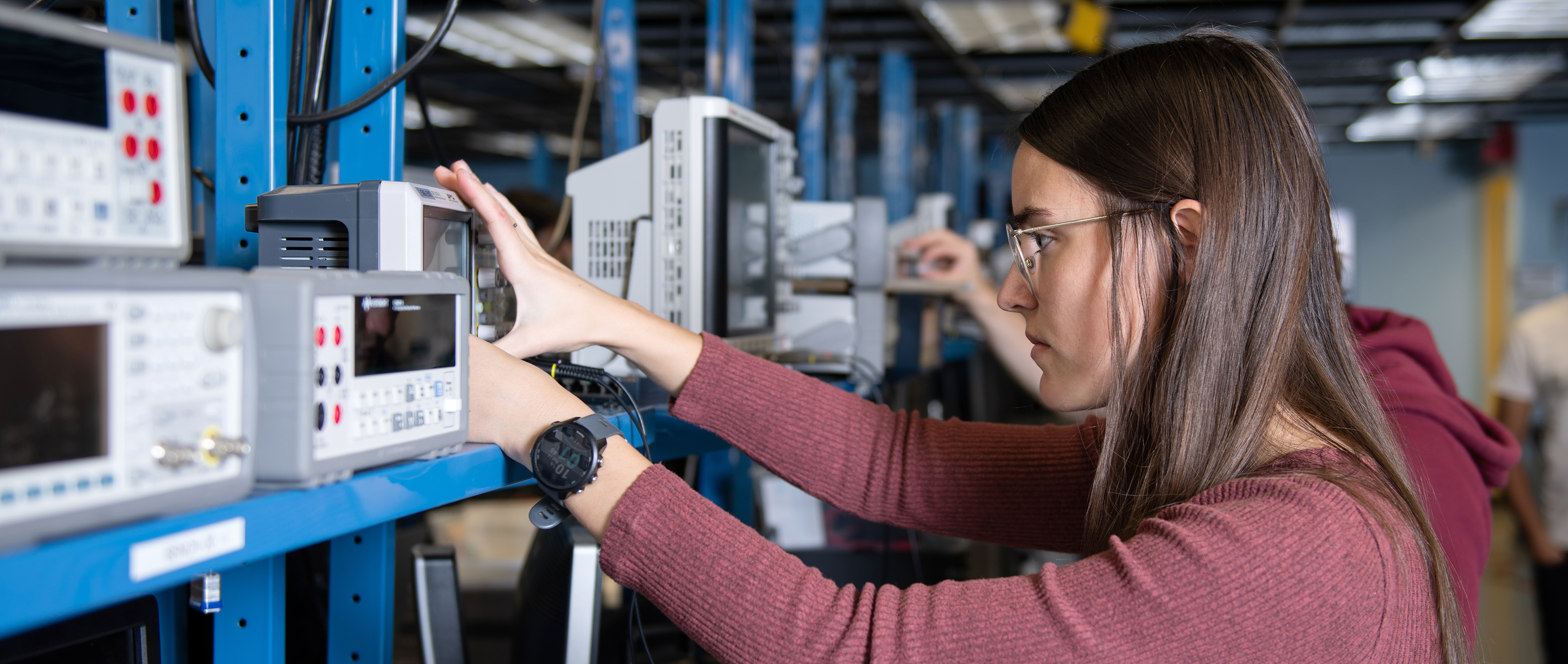 Female student works on an electrical engineering project in a lab