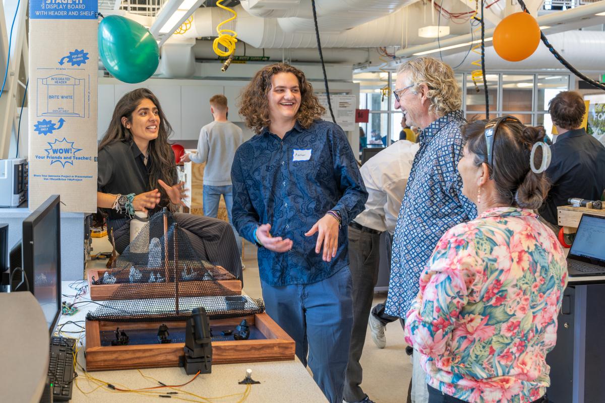 Two students show off their project to visitors at the spring 2024 IDE Expo