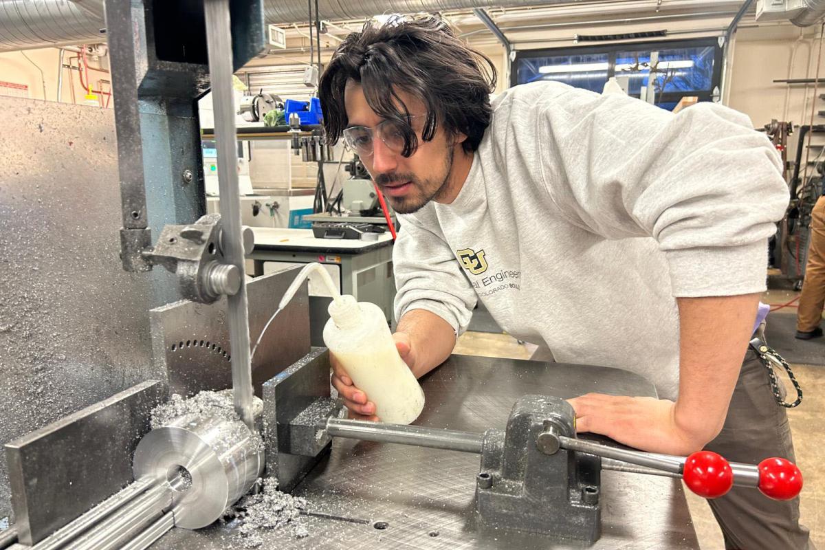 A student works to fabricate parts of the automated X-ray EOD device