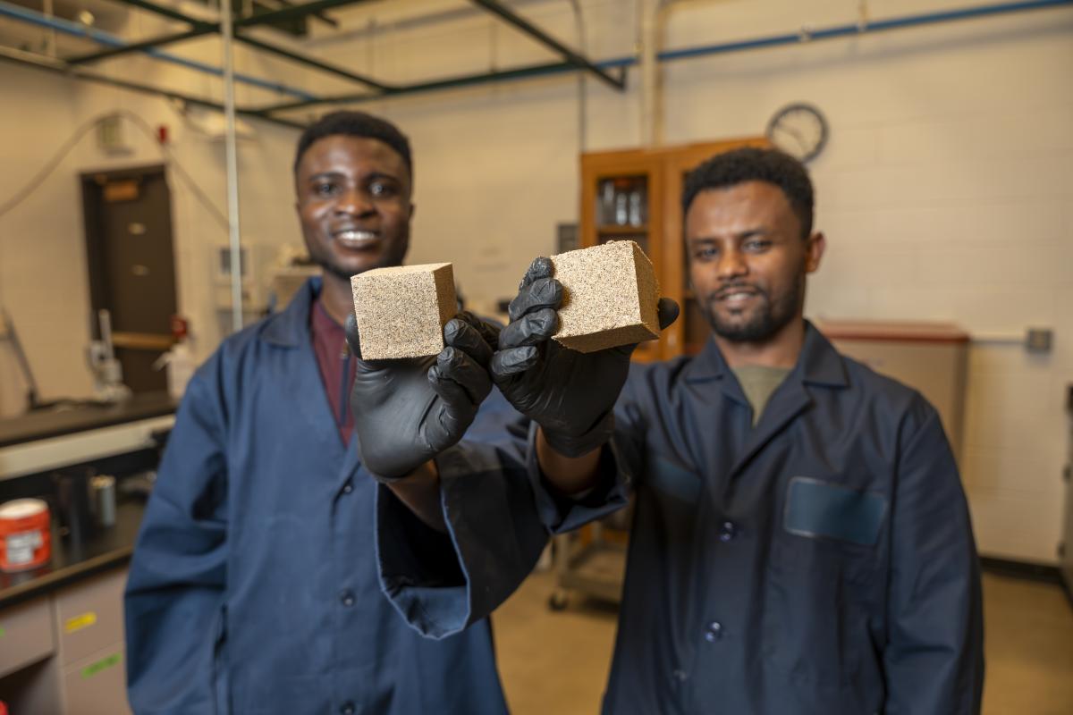 Students holding up building materials, CVEN lab