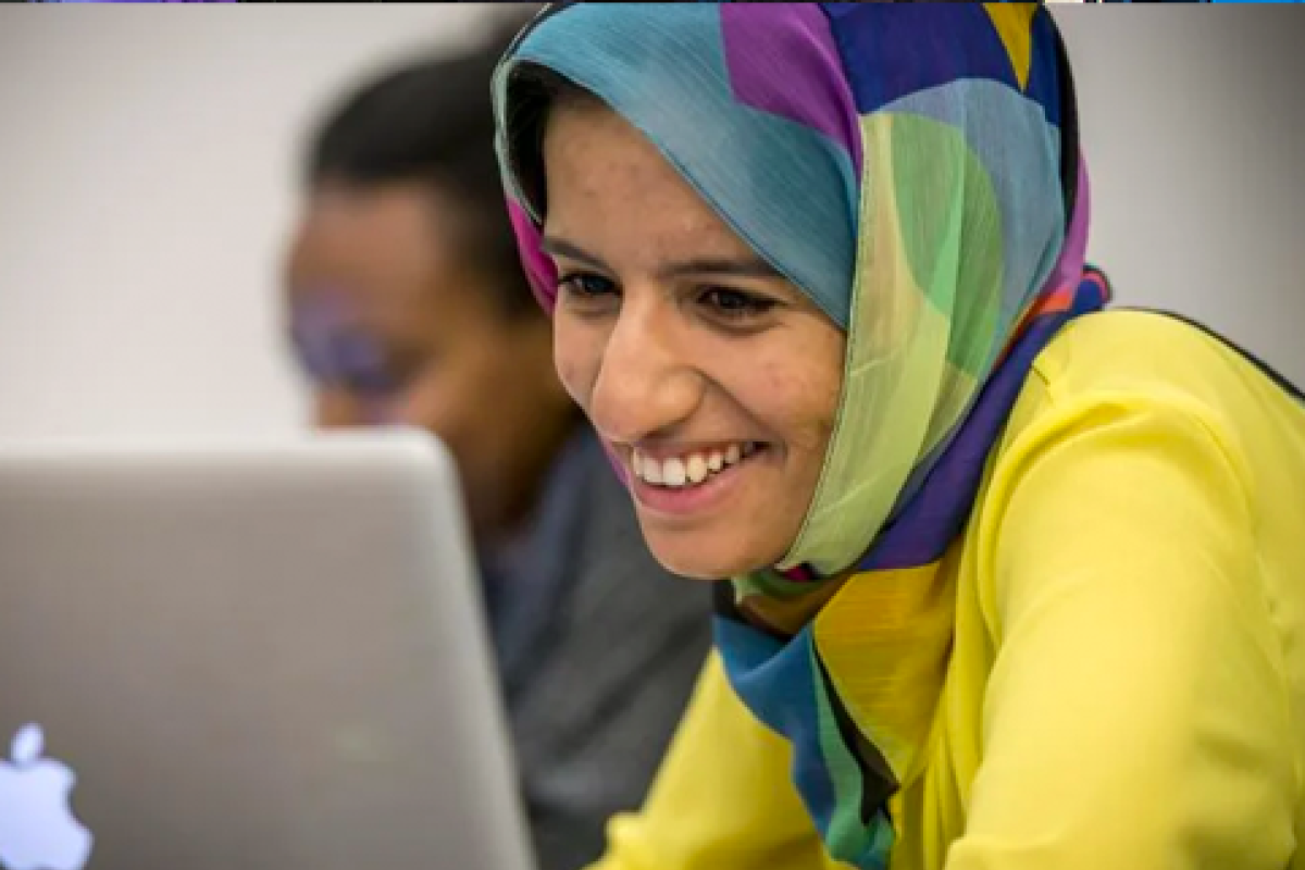 Female student smiling in front of a computer