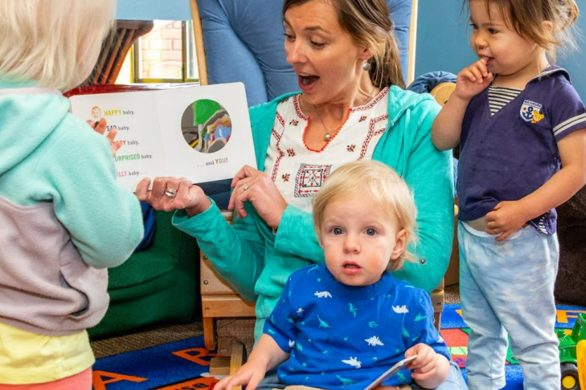 A staff member reads to children at the CU Children's Center