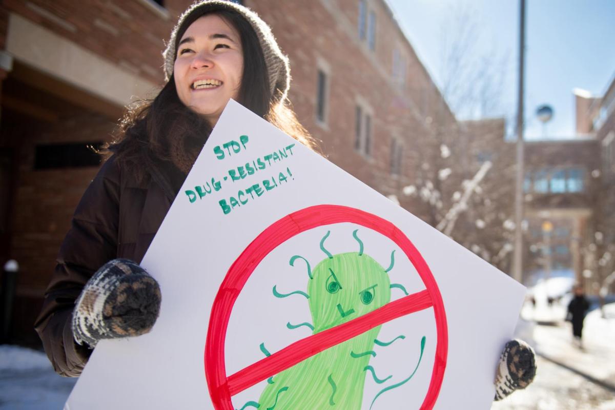 Student holding a sign about antimicrobial resistance