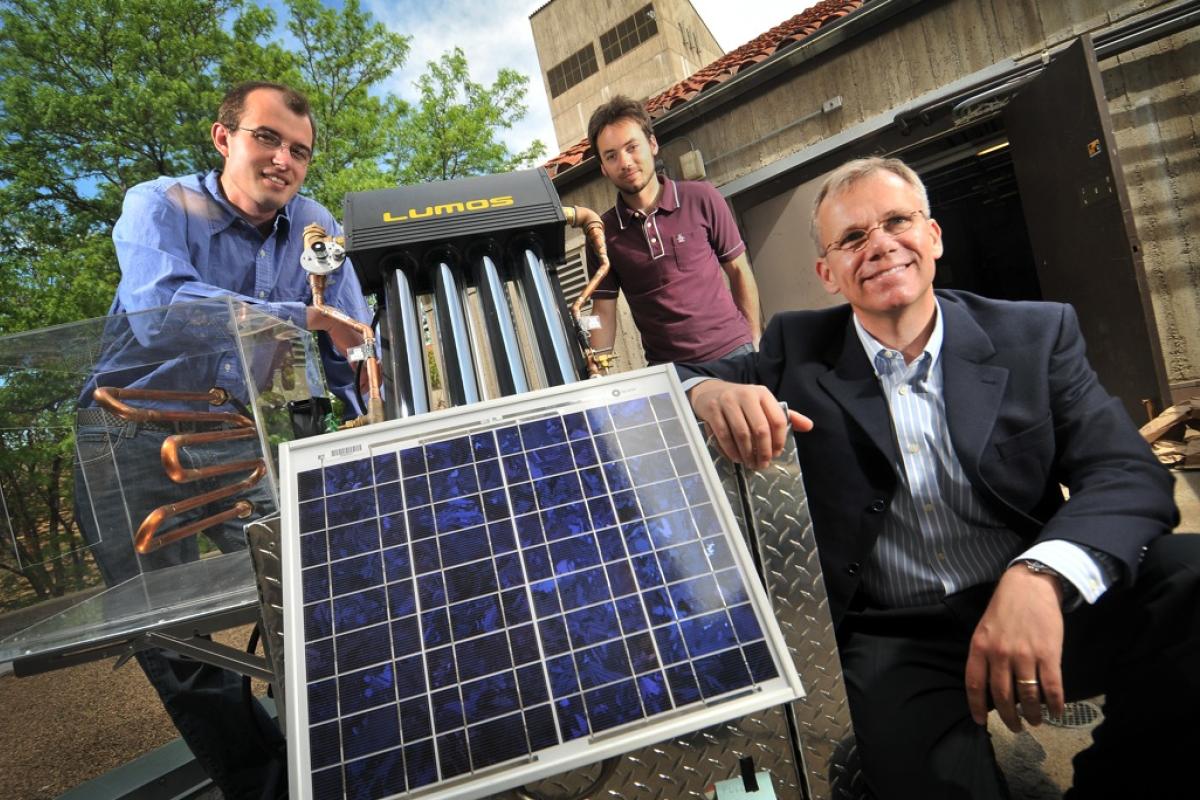 Professor and students looking at solar panel