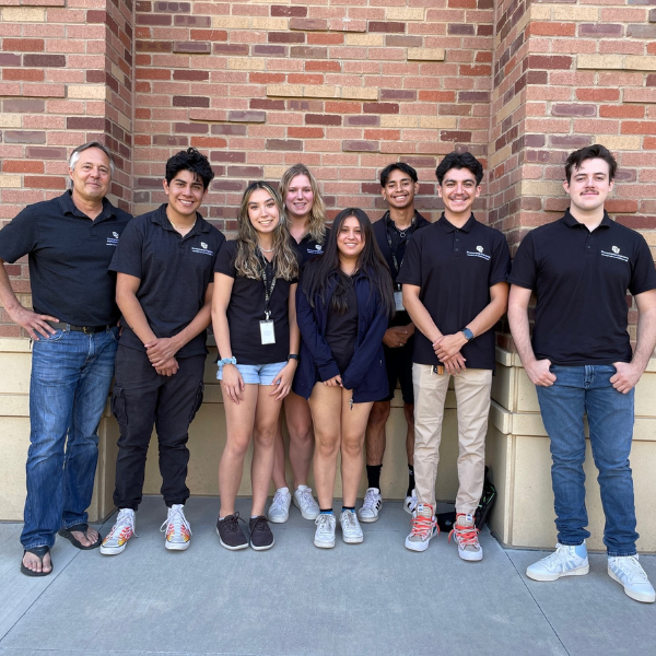 Dr. Mark Hernandez standing with students wearing University of Colorado Boulder polos