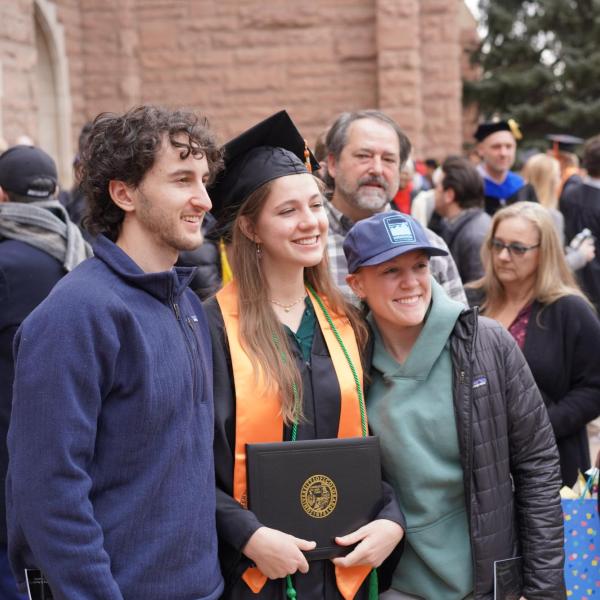 Grad posing for photo with friends