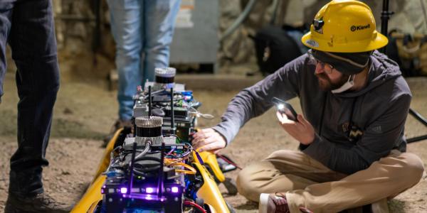 Harlow inspecting one of the robots before activation.