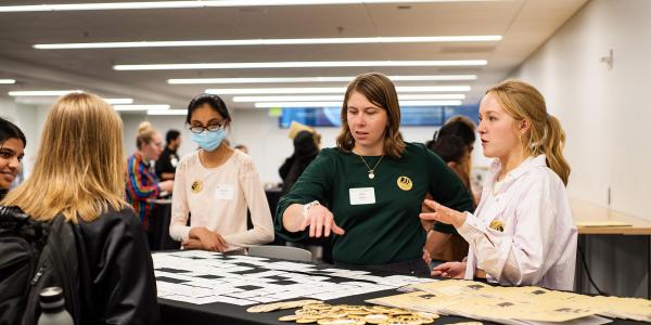 Three staff members work a check-in table for a college event