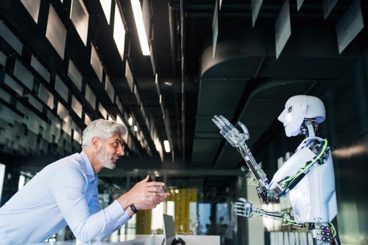 A man and a robot talking to each other 