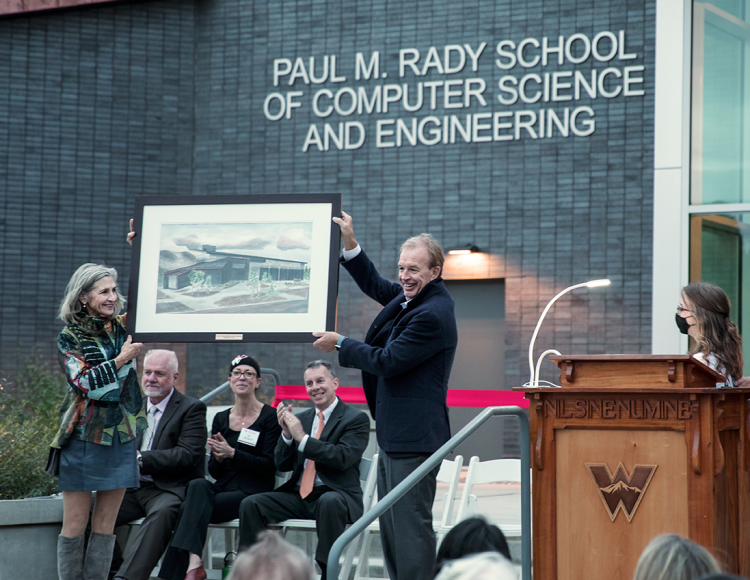 Paul and Katy Rady hold a rendering of the new Rady School building at the ribbon-cutting event in Gunnison.