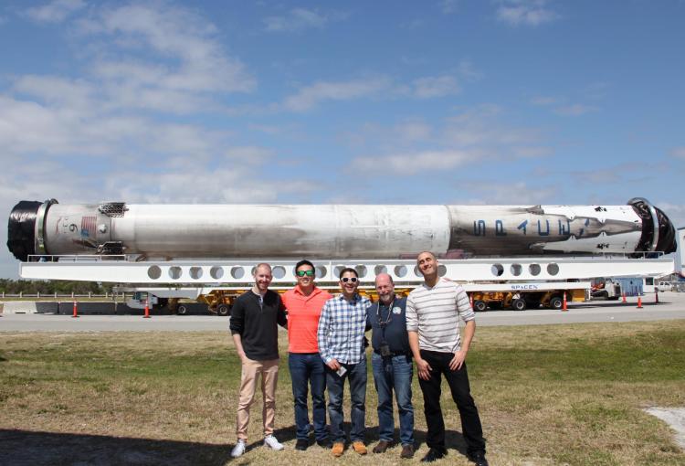 Members of the science and implementation team at Kennedy Space Center with a space-proven Falcon 9 rocket on the background. From left to right: Eric Yarns (KU), Kevin Ngo (KU), Luis Zea (CU), Dr. Joe Tash (KU), and Sam Piper (CU)