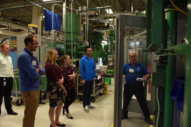 A group of students in a production facility with a Ball employee.