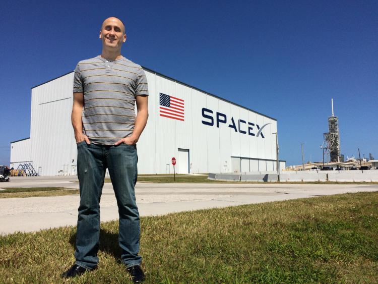 Sam Piper, aerospace engineering student at CU spearheaded the hardware development effort for the Micro-11 experiment. Launchpad 39A on the background (this is one of the two launchpads used during the Apollo and Space Shuttle programs and is now leased by SpaceX).