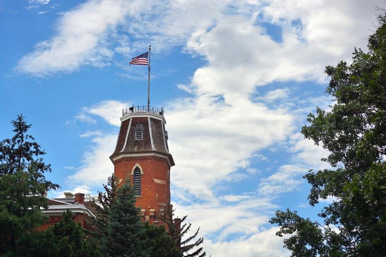 Picture of Old Main on CU Boulder's campus with American Flag