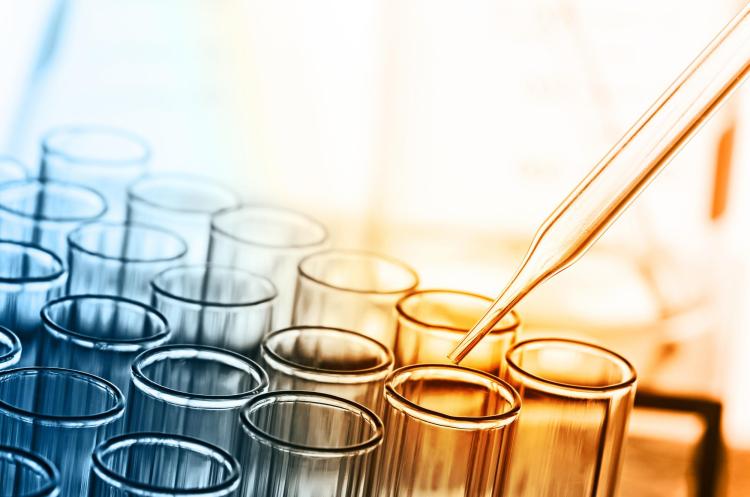 Test beakers being filled in blue and orange light