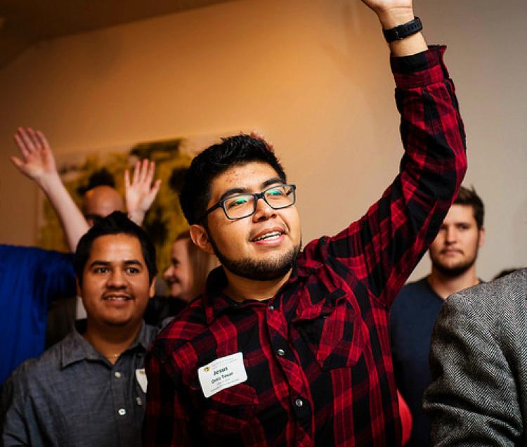 alumni raise hands at event