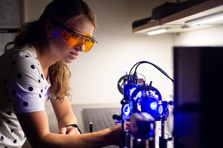 A student working in the lab with lasers