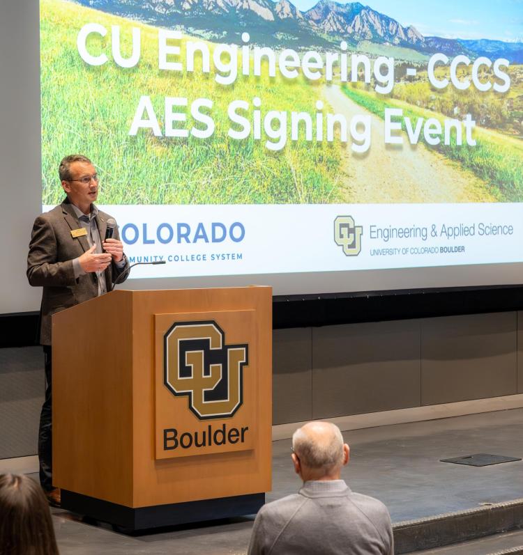 Dean Keith Molenaar speaks at a podium at the community college agreement signing celebration