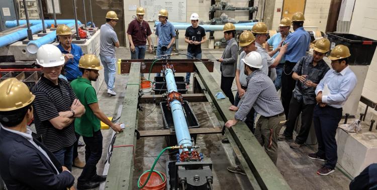A group of water experts gather around the seismic testing equipment in the CIEST lab.