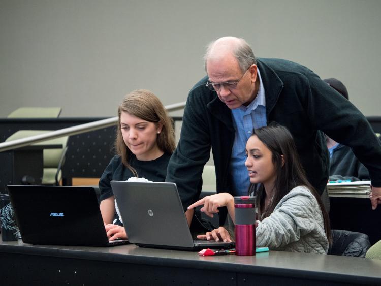 David Clough helping students in classroom