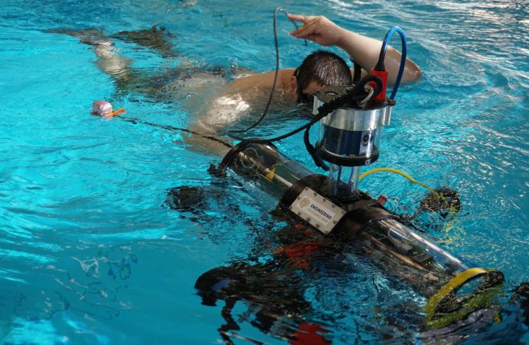 Student in the pool with the RoboSub system