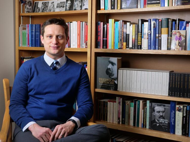 Professor Shilo Brooks near bookcase
