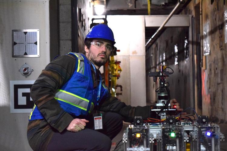 A student in the tunnel near the course with the robot