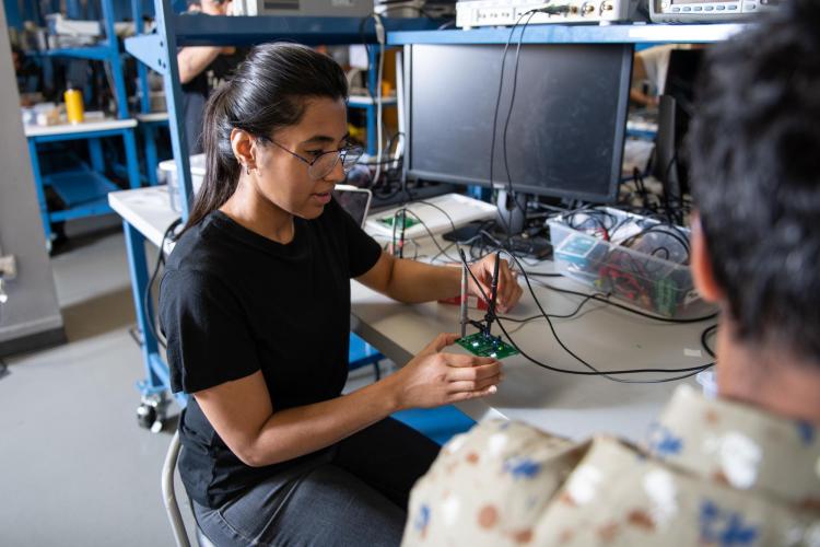 A student works with electronics in a lab
