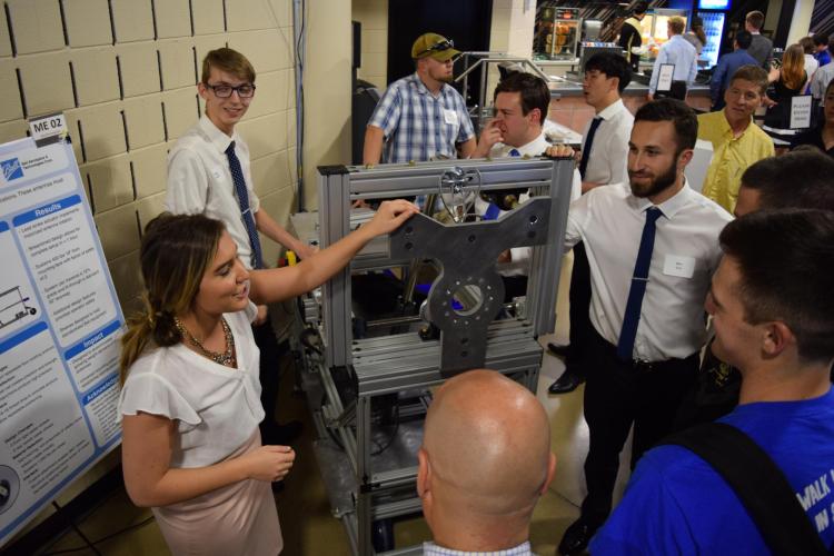 A student discussing her project with Expo attendees.