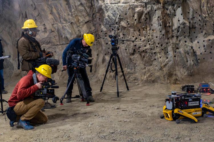 Videographers from CBS news in the mine with the robots.