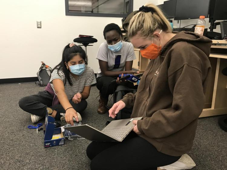 CU Boulder students Halle Sago, Ryan Carroll and Sylvia Akol discuss data input for built environment surveys in Denver high school classrooms.